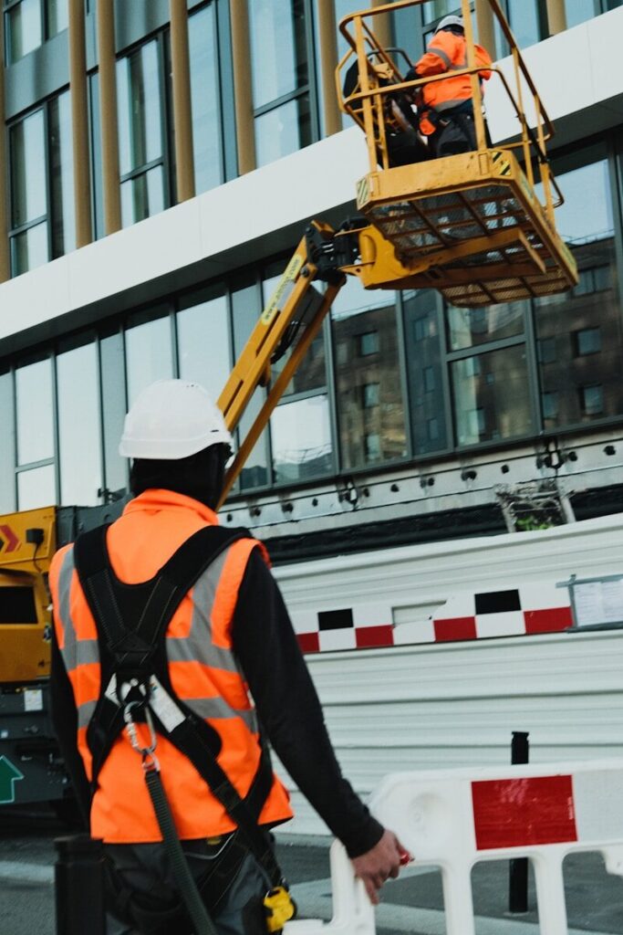 a man in an orange safety vest standing in front of a building