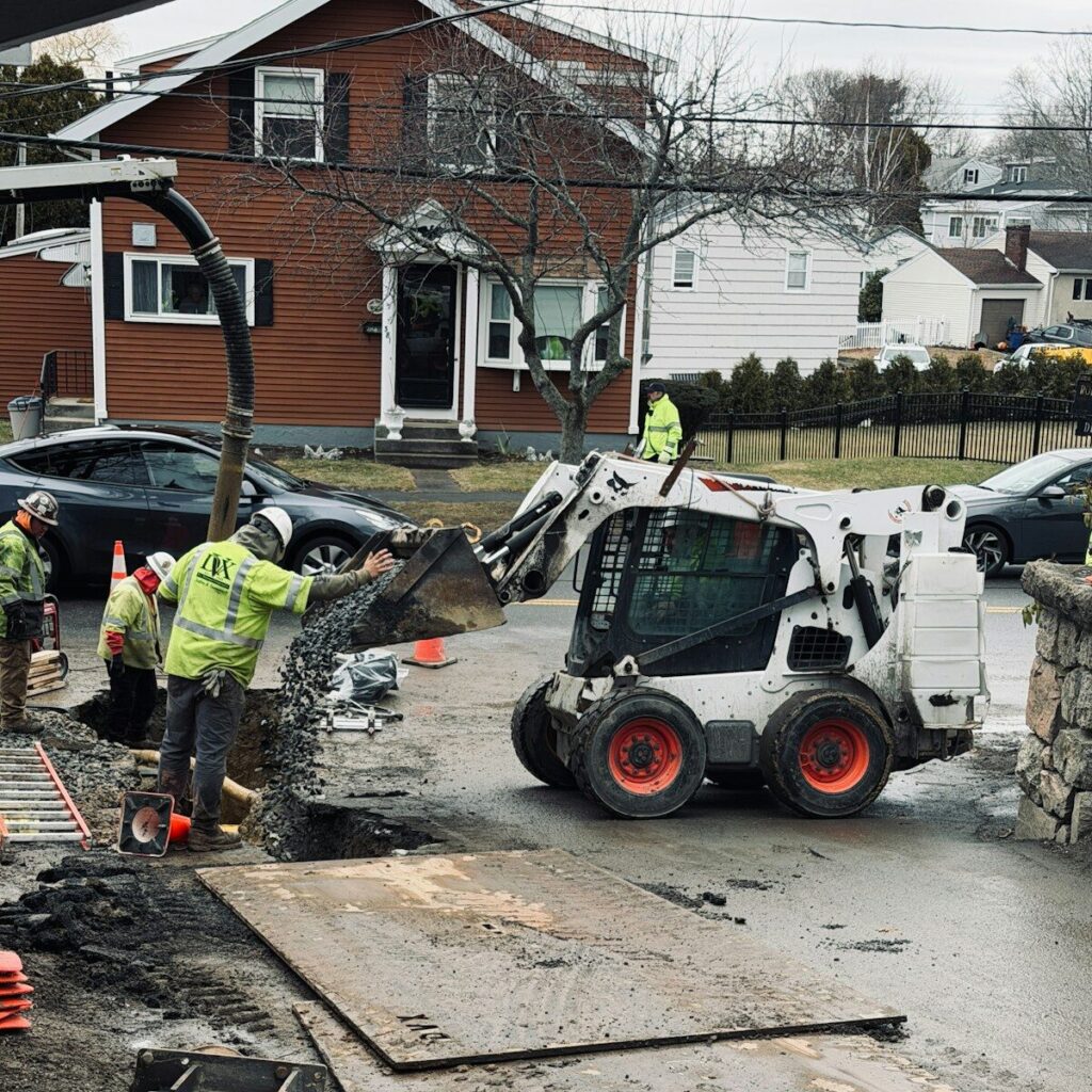 Workers use a skid steer loader for construction work.